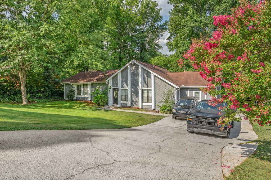Front exterior with long driveway and crepe myrtle in bloom