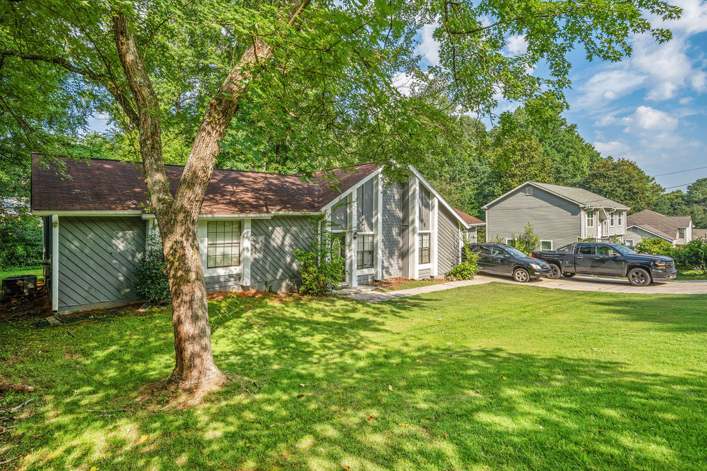 Angled front view of the home with mature shade tree