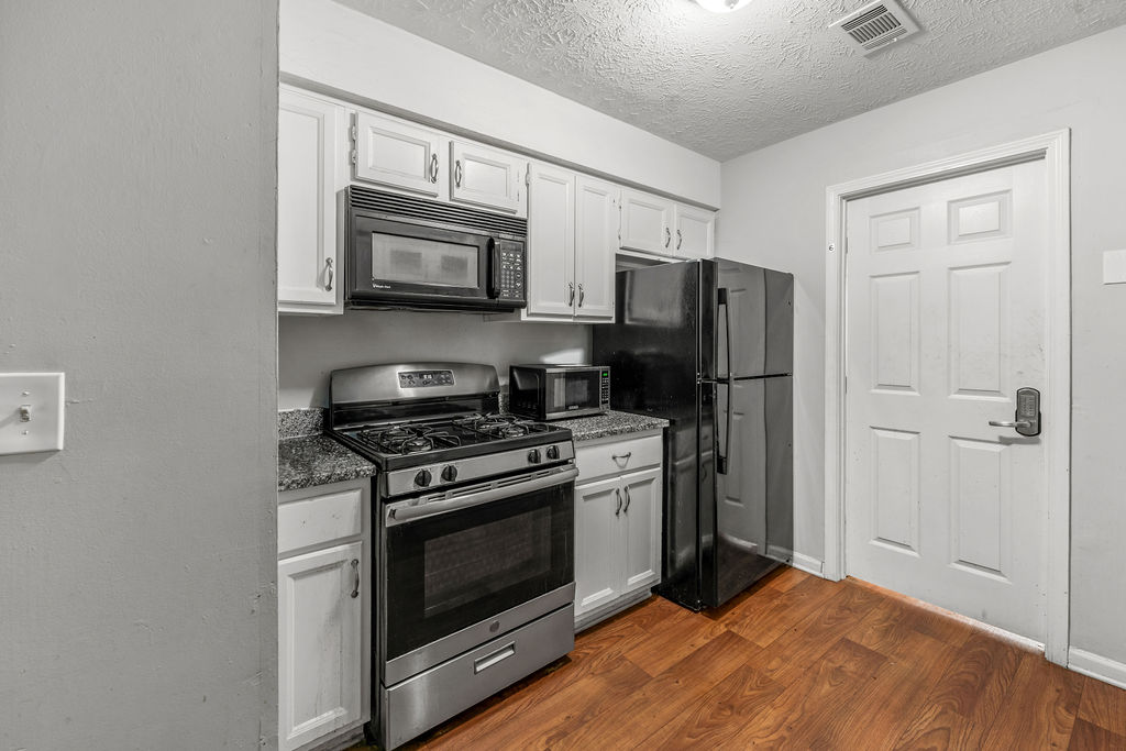 Kitchen with gas range, microwave, and refrigerator