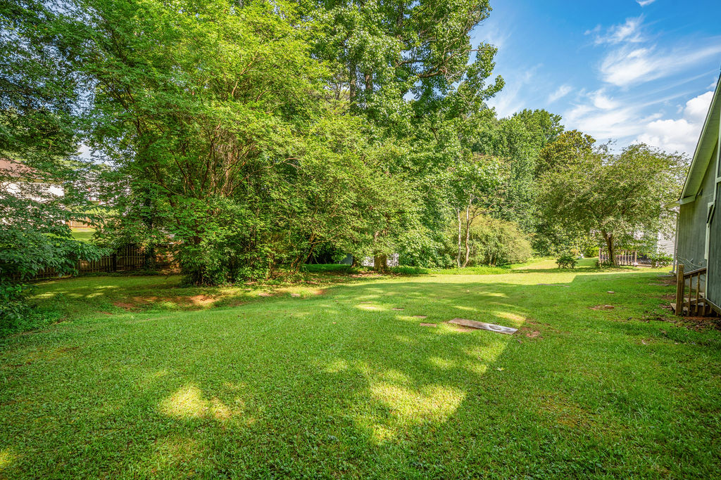 Large level backyard framed by mature trees