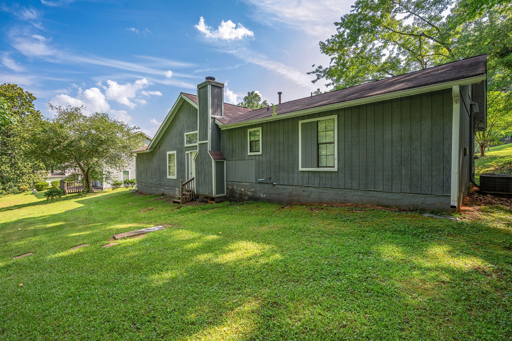 Rear exterior with chimney and side yard